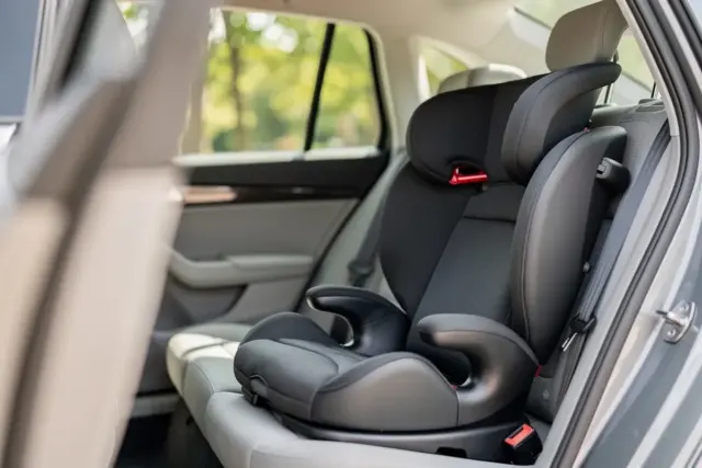 Kindersitzerhöhung mit Rückenlehne und Isofix auf der Rückbank eines Autos